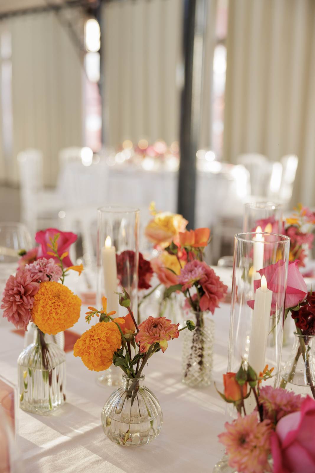 Small posies of dahlias and marigolds among candles