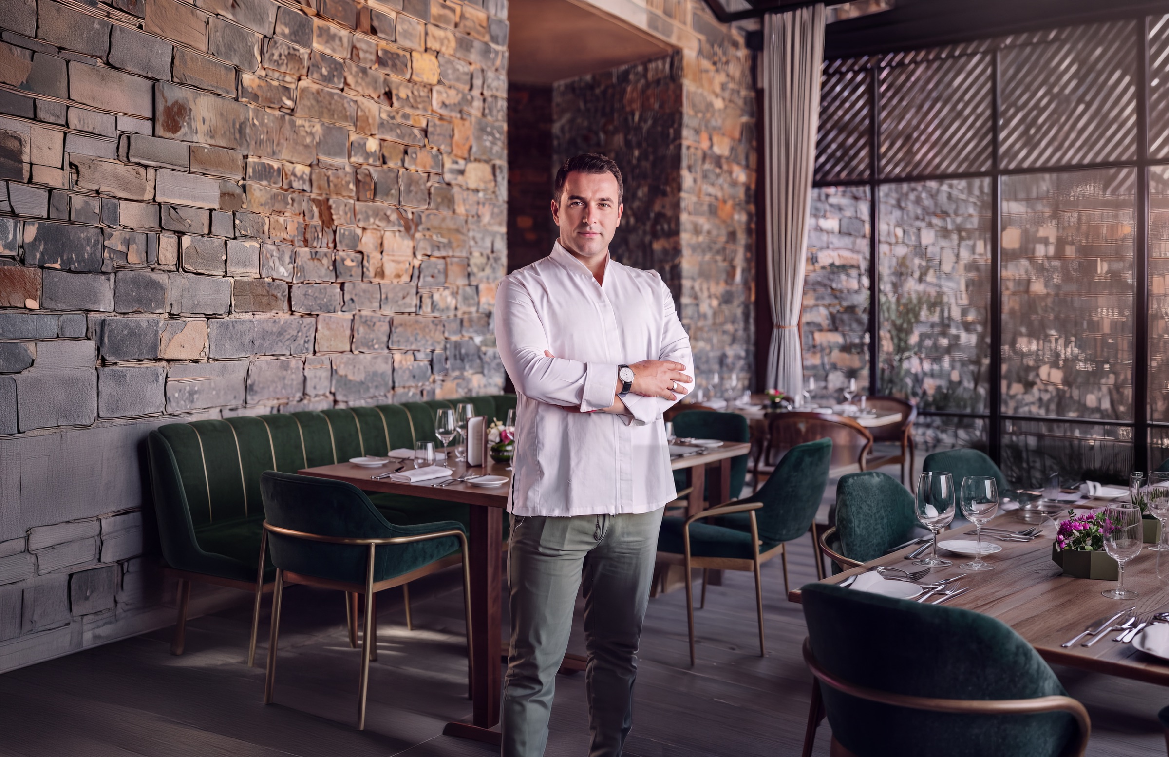 A chef in whites in the dining room of their restaurant