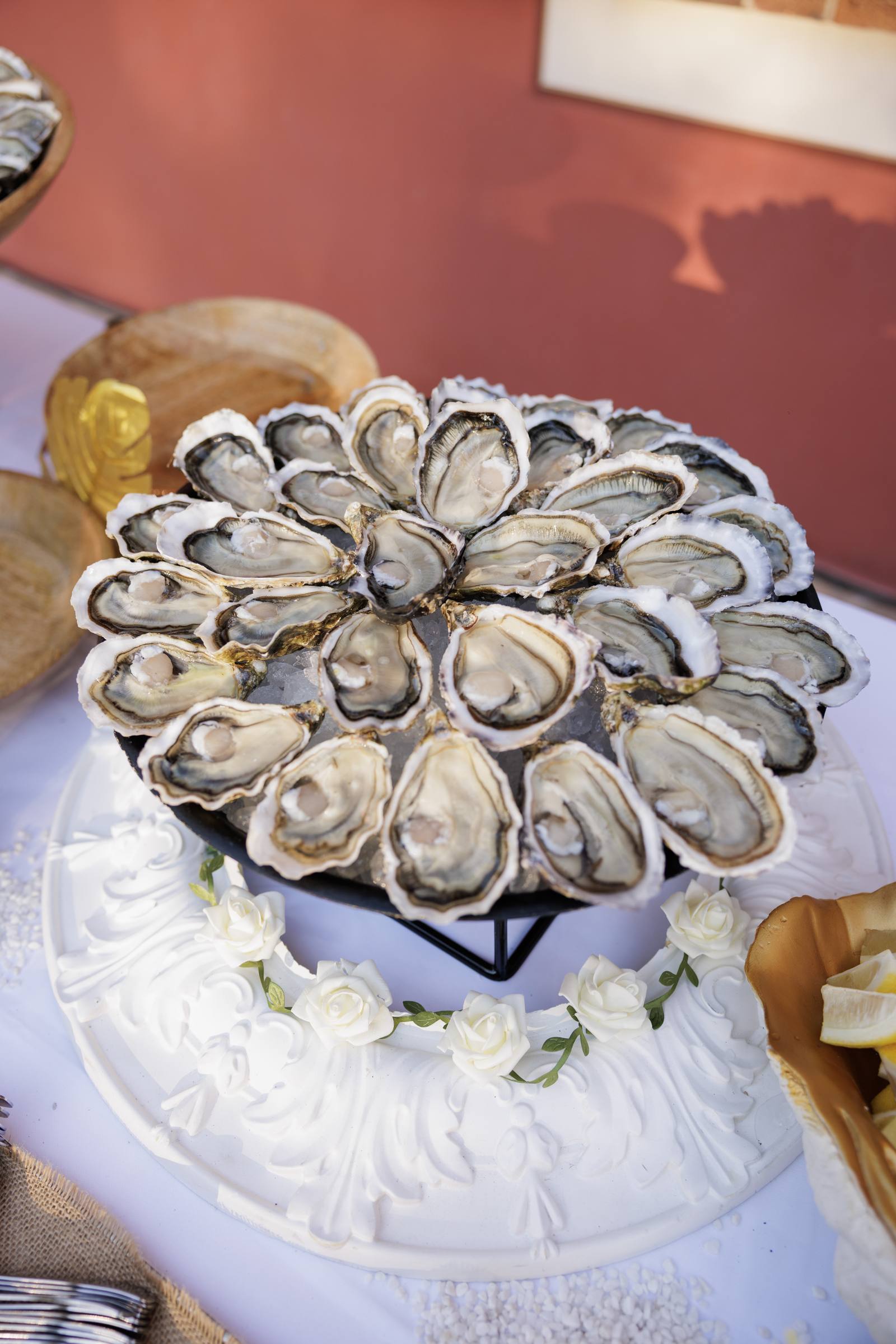 A platter of opened oysters, arranged in a rosette
