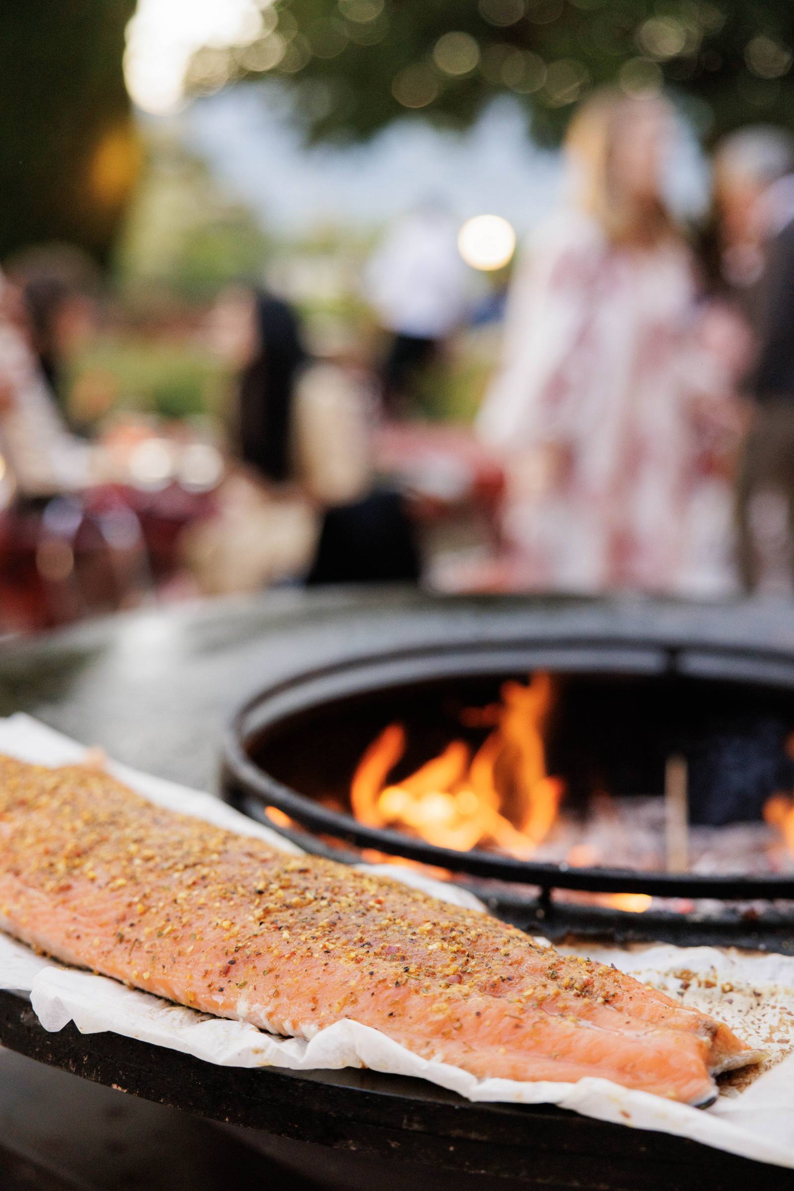 A side of salmon on the brasero, in front of the guests