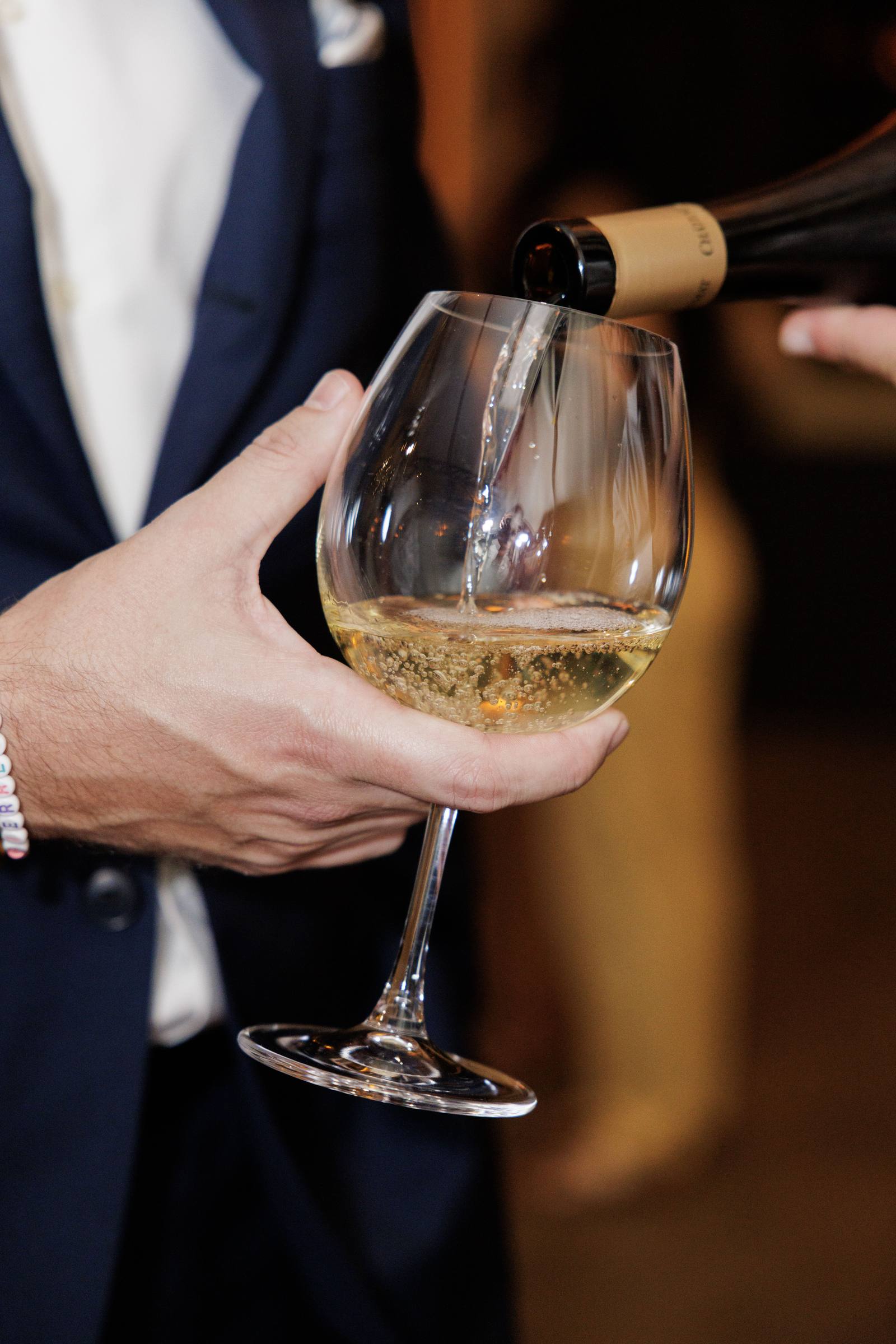 A glass of white wine poured for a guest