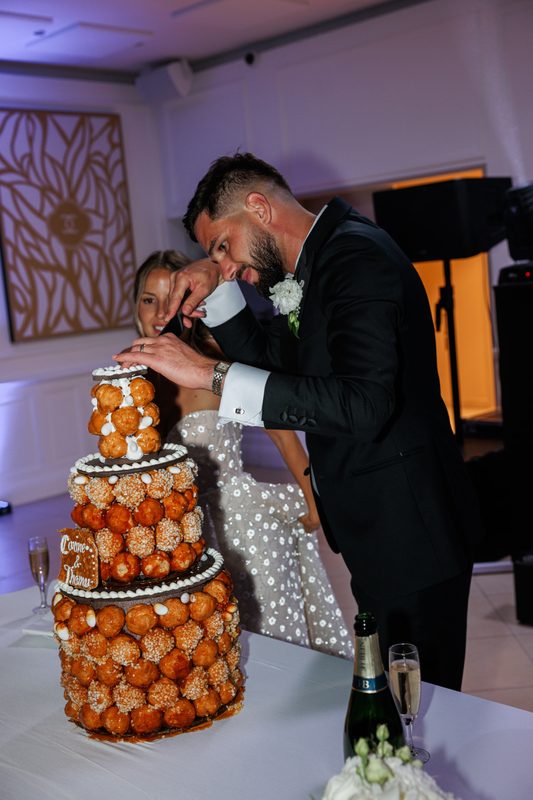 A couple cutting a caramelised choux tower